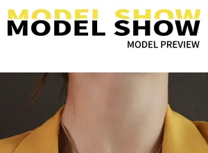 Collana minimalista in acciaio al titanio dorato indossata da modella con blazer giallo