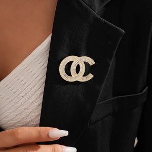 Golden double C brooch with cubic zirconia and pearls on black suit lapel accessory