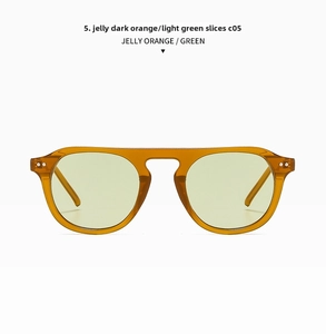 Close-up of translucent orange round sunglasses frame with light green lenses and rivet detail