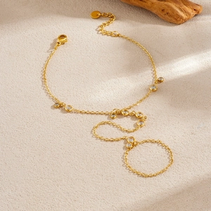 Bracelet bague élégant en or avec pierres de zircon sur un fond beige minimaliste