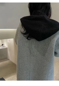 Detail of grey herringbone coat with integrated black hood shown from the back view