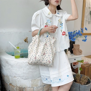 Detail of floral quilted cotton tote bag paired with white floral embroidery shirt set