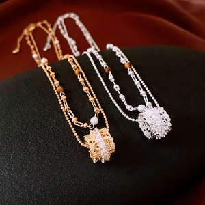 Macro view of double-layered necklaces featuring tiger eye stones, pearls and zircon details