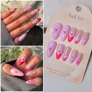 Details von rosa Mandel-Press-on-Nägeln mit 3D-Blumen, Perlen und Meerjungfrauen-Linien