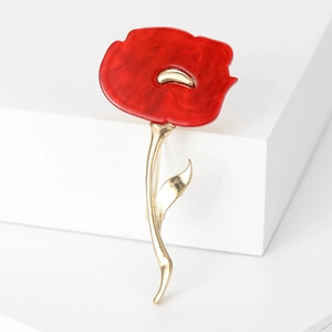 Elegant red flower brooch with gold petals on a white platform for suits and coats