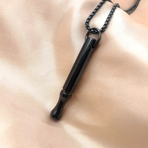 Close-up of black meditation breathing necklace for anxiety relief on satin fabric