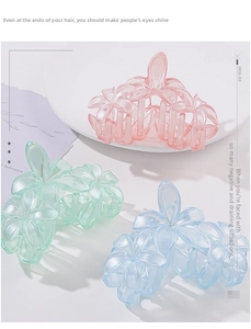 Detailed macro shot of three translucent resin flower hair claws in pastel pink green and blue
