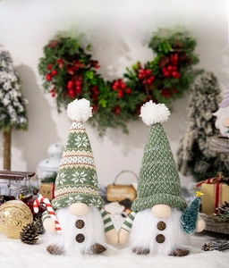 Detailed view of Christmas gnomes with knit hats holding candy canes and mini pine trees