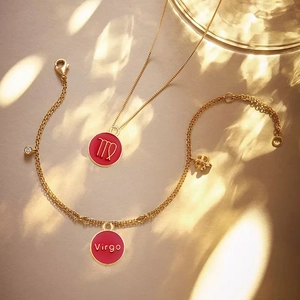 Golden zodiac jewelry set with red Virgo pendant, necklace and bracelet set in warm light