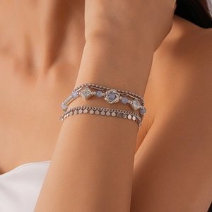 Detail of silver multi-layer bohemian bracelet set with blue beads and floral charms