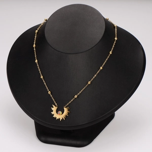 Golden stainless steel necklace with sunburst eye pendant on display stand