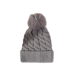 Detailed knit texture and large faux fur pompom on a gray winter beanie hat