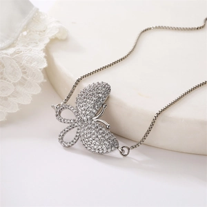Macro shot of silver butterfly pendant with micro-pave zircons and delicate box chain