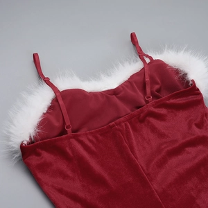 Detail van rode fluwelen kerstjurk met witte imitatiebontrand en verstelbare bandjes