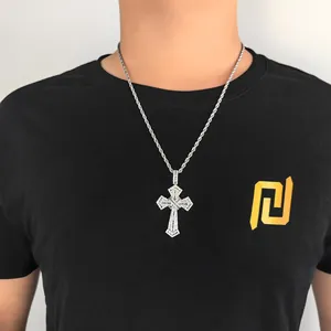 Detail of hip hop cross pendant with paved zircons on a silver rope chain necklace