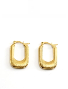 Détail macro de boucles d'oreilles en U plaquées or 18 carats avec fine texture nervurée