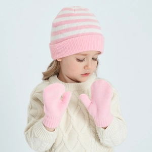 Detail of pink striped knit beanie and matching gloves on a child for winter warmth
