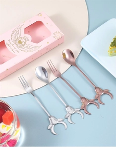 Detail view of 4-piece silver and rose gold metal spoon and fork set with deer head handles