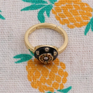 Detailed top view of golden evil eye ring with black zircon setting and colorful crystals