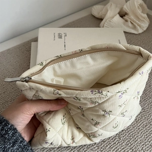 Macro shot of floral corduroy quilted makeup bag showing metal zipper and lining