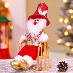 Detail of Santa Claus plush doll with red sequins sitting on a miniature rocking chair