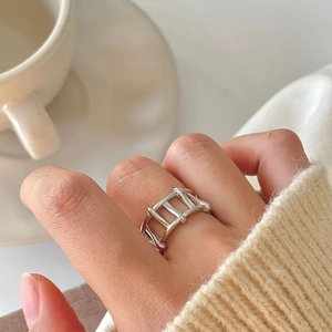 Minimalist 925 sterling silver hollow geometric ring worn on index finger with coffee cup