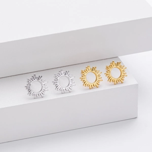 Detailed view of S925 silver sun stud earrings in gold and silver finishes on display
