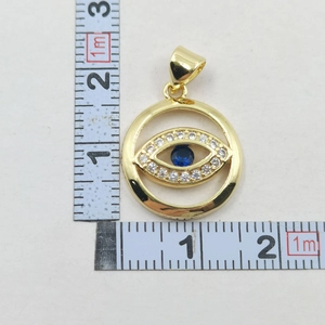 Macro shot showing evil eye pendant dimensions with gold plating and blue crystals