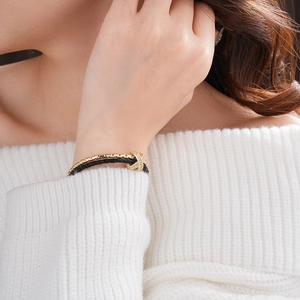 Close-up of gold-plated double-layer bracelet with crisscross pavé zircon detail
