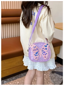 Detail of lavender sequin kids crossbody bag with large butterfly patch and floral zipper charm