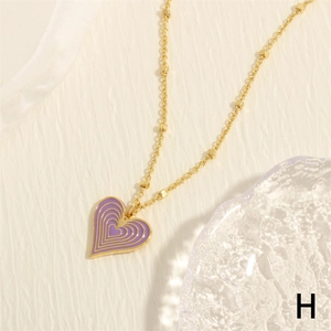 Macro view of purple heart enamel pendant with gold-plated bead chain and gold edges