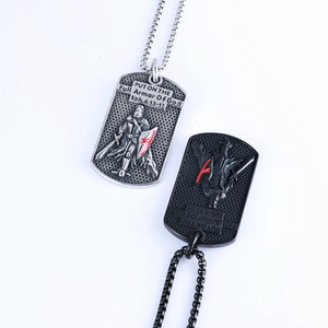 Detail of silver and black dog tag necklaces with knight engraving and biblical verse
