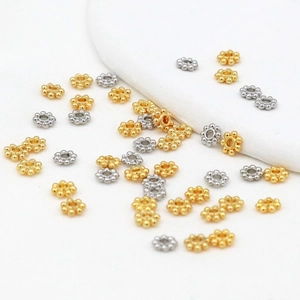 Macro view of 4mm snowflake and gear-shaped metal spacers in gold and silver plating