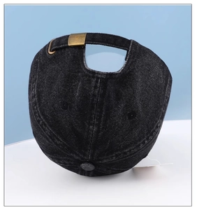 Close-up of black denim baseball cap with adjustable antique bronze metal buckle back strap