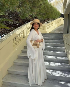 Close-up of elegant V-neckline with pleated lace trim on a white flowing maxi dress