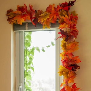 Detalle de hojas de arce artificiales de otoño en naranja y rojo para decorar el hogar
