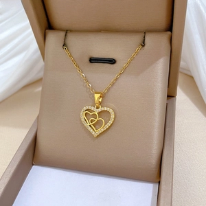 Detailed close-up of 18K gold heart necklace with zircon inlay on silk jewelry box