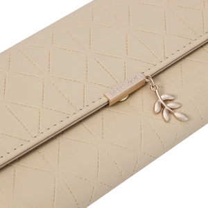 Detail der beige gesteppten Ledergeldbörse mit goldenem Blattanhänger und Metallakzent
