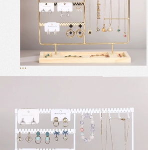 Detail view of multi-layer wood and iron jewelry stand with gold and white finishes