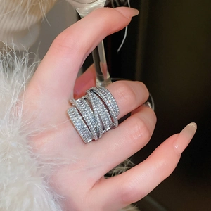 Macro shot of silver-toned zircon multi-layer wrap ring worn on finger in luxury setting