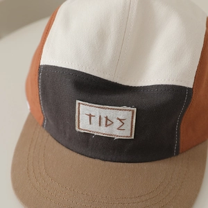 Dettaglio macro del ricamo TIDE su cappello hip hop a 5 pannelli per bambini bicolore