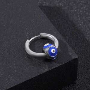 Polished silver titanium steel hoop earrings featuring a blue evil eye bead on black background