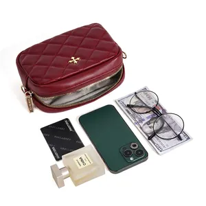 Quilted burgundy phone crossbody bag with gold logo showing storage capacity for essentials