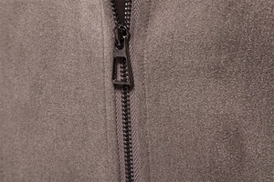 Detailed close-up of premium metal zipper and textured suede fabric on the black jacket
