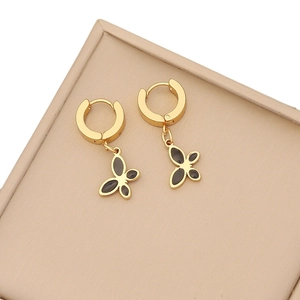 Elegant gold butterfly earrings with black inlay displayed in a minimalist jewelry box