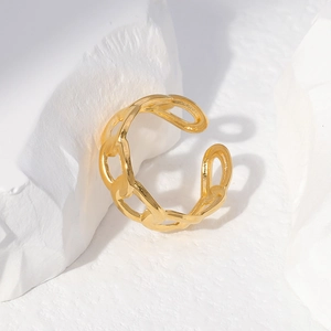 Close-up of golden chain texture open ring on a white minimalist stone display