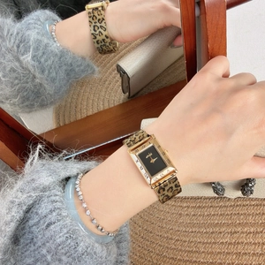 Elegant gold rectangular watch with leopard print strap and Roman numerals on black dial