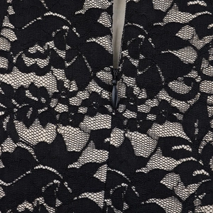 Vue détaillée de la fermeture éclair invisible et de la dentelle noire sur robe beige