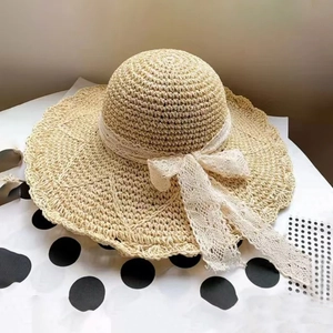 Cappello da sole in paglia beige a tesa larga con fiocco in pizzo per il mare