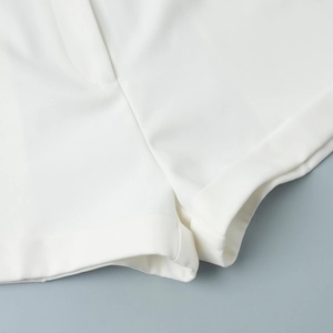 Close-up of white suit shorts showing twill texture and neat double-stitched hem details